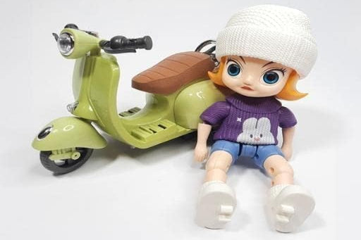 Toy figure of a girl with a scooter on a white background